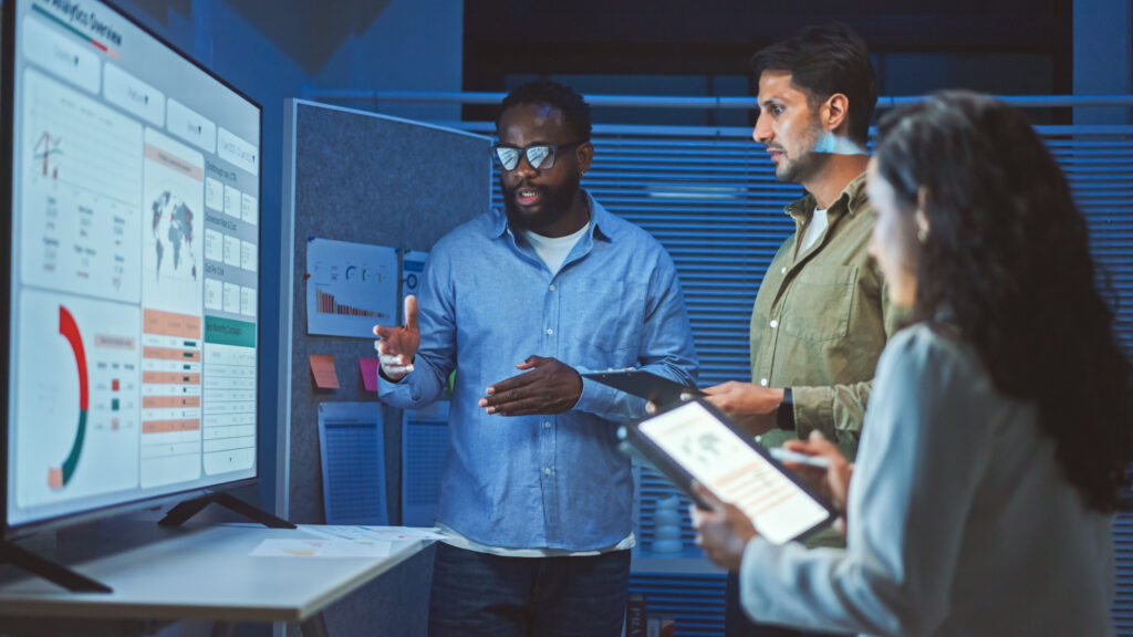 three salesprofessionals standing in front of data