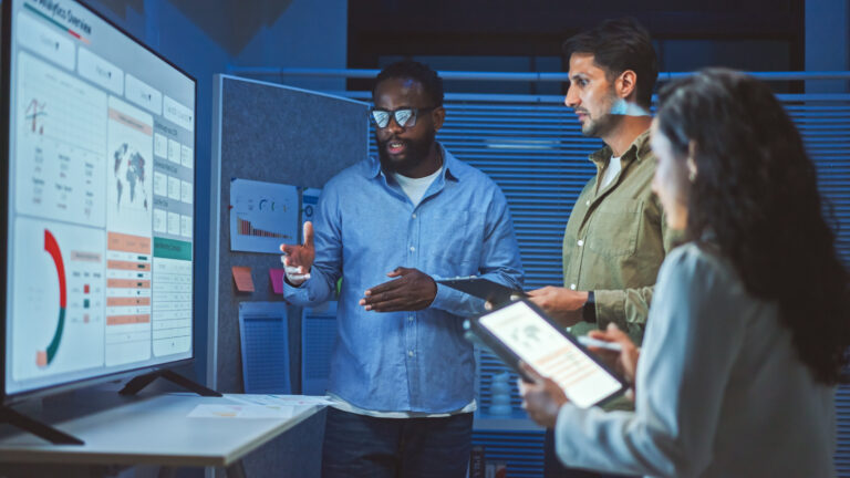 three salesprofessionals standing in front of data