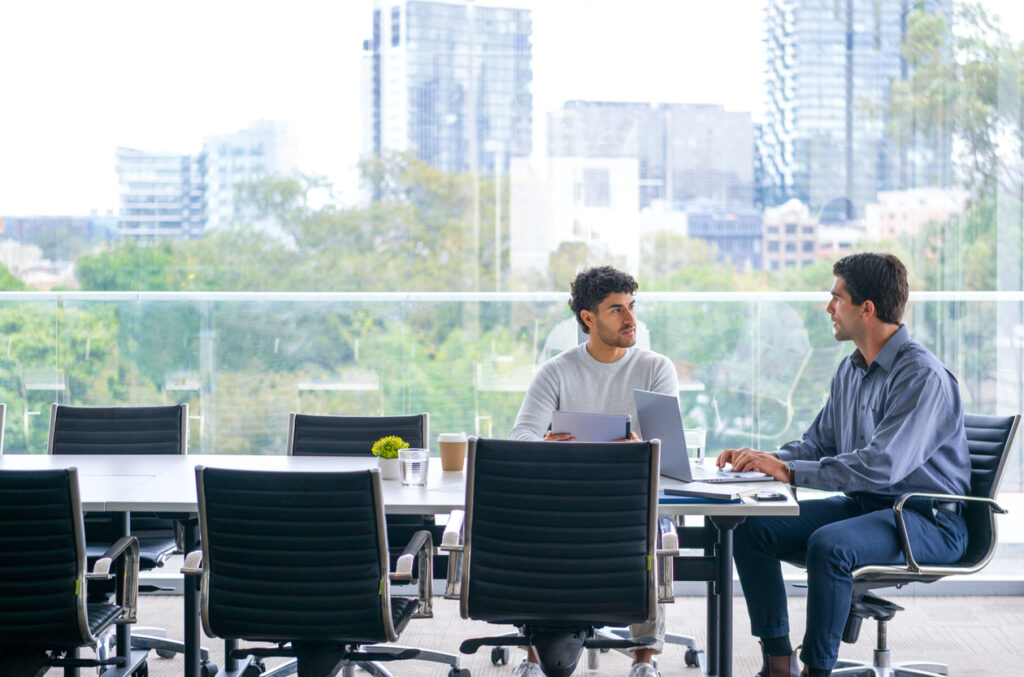 Two sales professionals sitting in the conference room interviewing