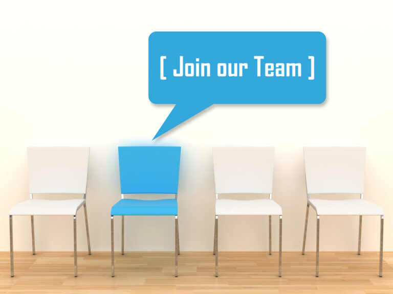 A photo of four chairs. Three are white and one is blue. The blue chair has a dialogue bubble - graphically added to the photo - that says, "Join our team."