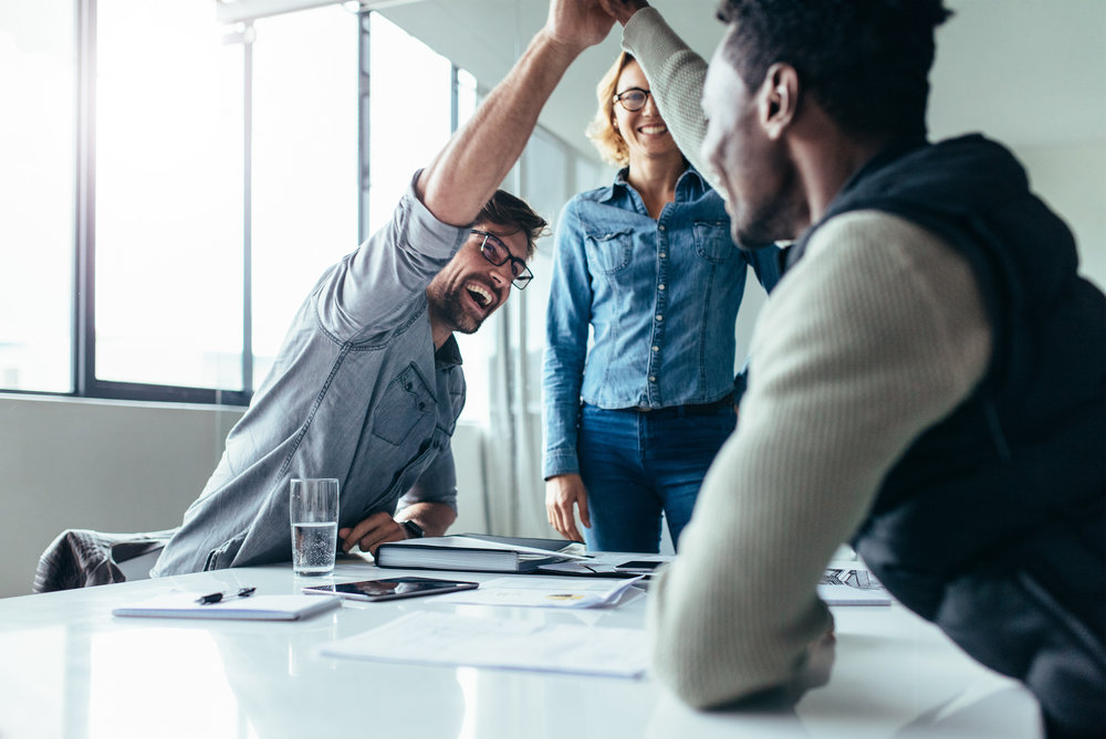 Happy business colleagues giving high-fives to each other.
