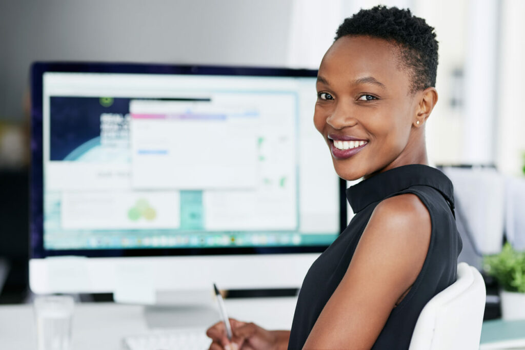 Woman at computer turning with a smile.