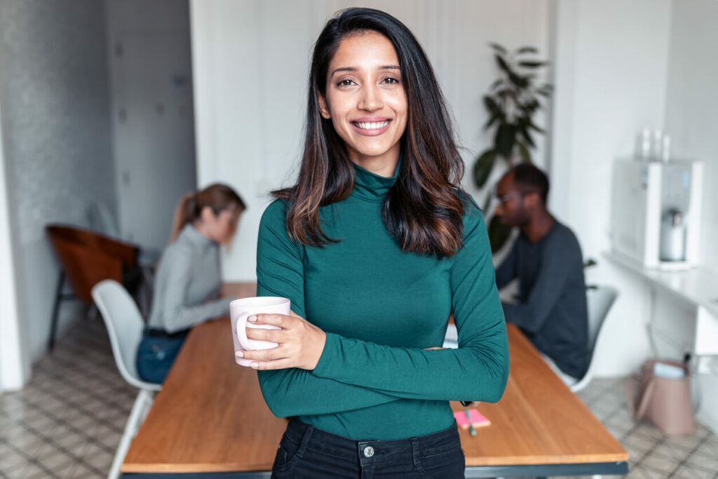 woman in green seater with coffee mug