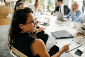 woman at computer table smiling baordroom