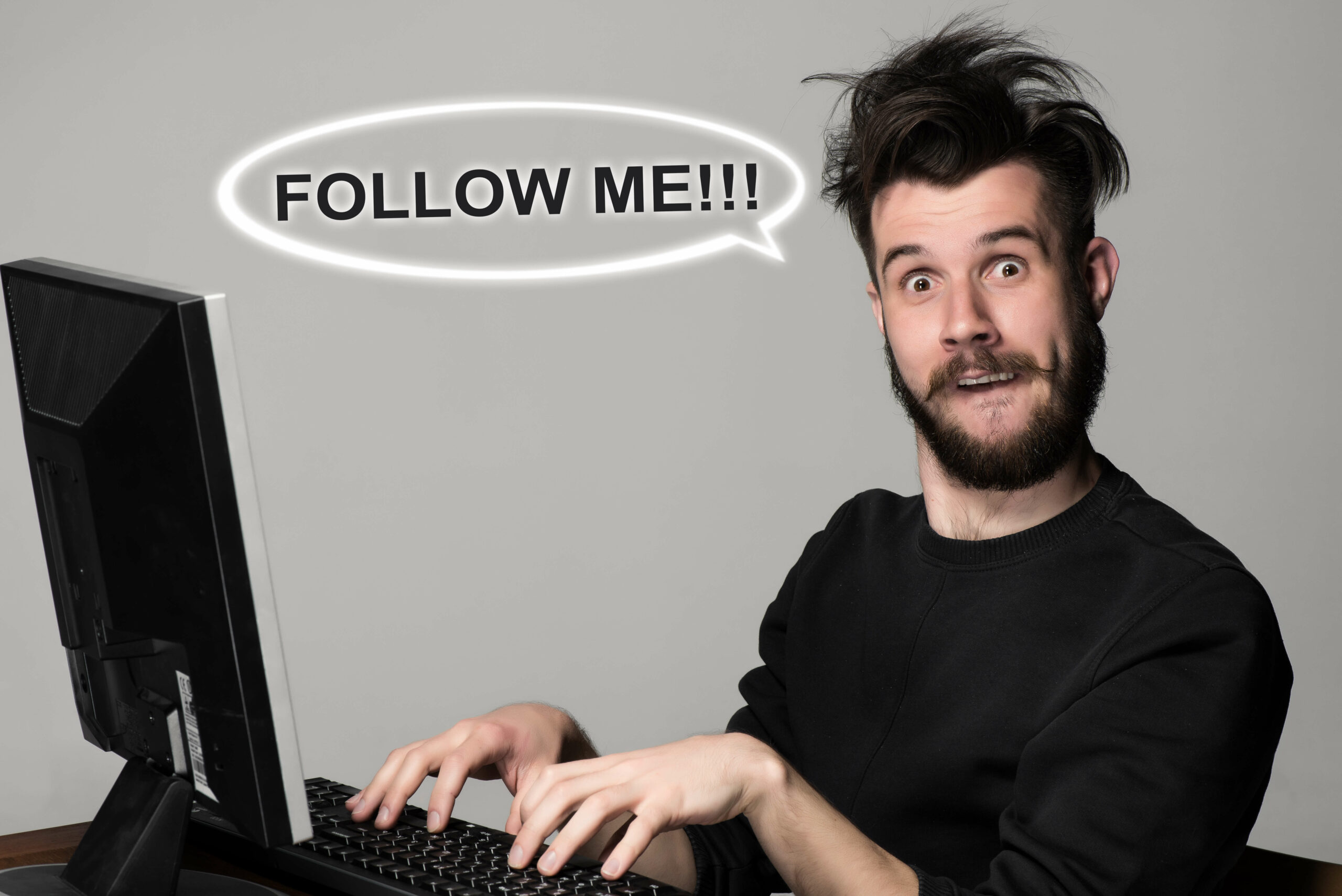 person at desk typing follow me sigh and messed up hair