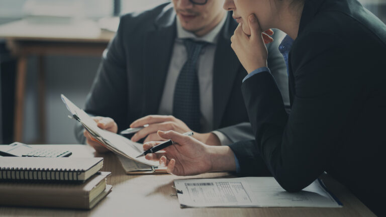 two people strategizing at their desk