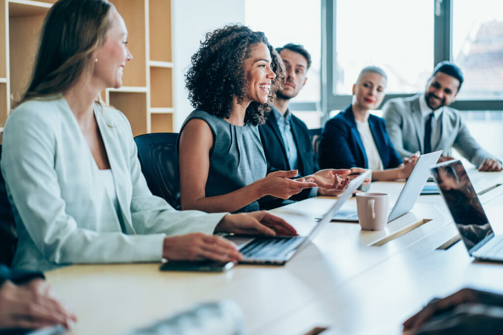 technology sales recruiting agency filled with software sales and marketing recruiters on laptops smiling in the conference room dressed in professional business attire