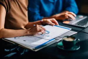 Two salespeople at a desk analyzing sales pipeline.