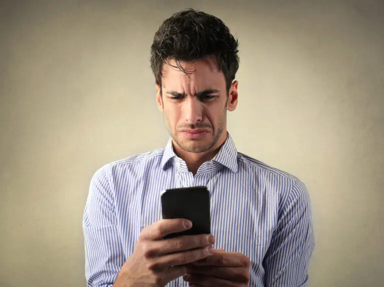 Salesperson looking at his phone in disbelief