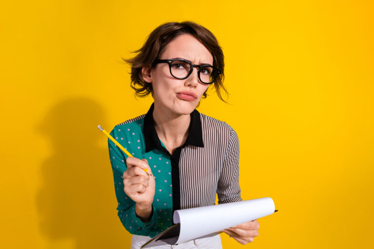 Photo of lovely minded woman wear stylish clothes hold paper list isolated on yellow color background. She's trying to decide which offer to sign.